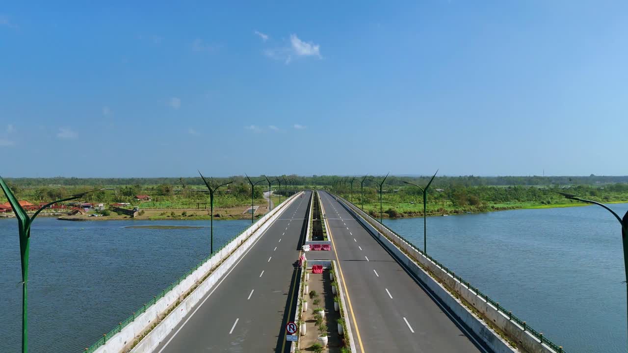 Drone flying moving forward over asphalt road on big bridge with car vehicles driving away from camera. 4K aerial view.