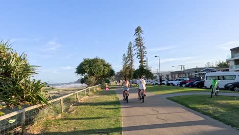 personas disfrutando de un día soleado en un camino junto al mar