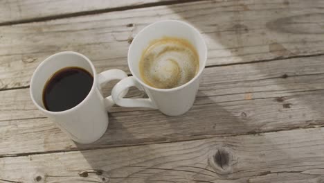 image of two white cup of black coffee on wooden background