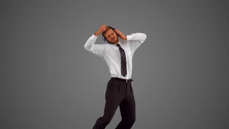 hombre de negocios saltando y escuchando música en fondo gris