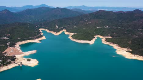 高島水庫的空中畫面右邊 藍色水,沙灘海岸線和綠色山丘,中國香港的聖昆半島