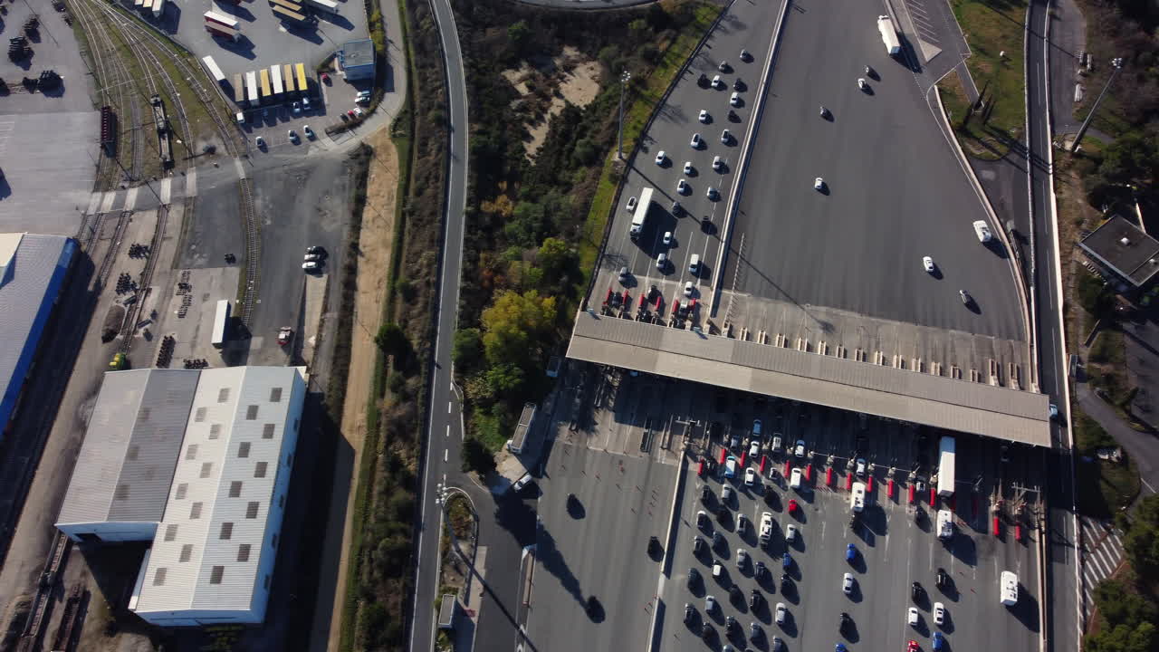 Aerial View of a Highway Toll Plaza with Traffic and Industrial Area