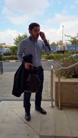 professional man texting on stairs outside office