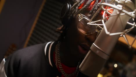 man singing into microphone in recording studio