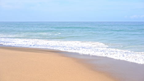 empty beach and tropical sea waves breaking on sand, full frame slow motion