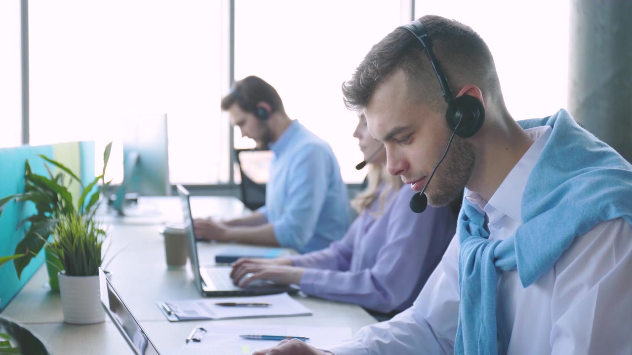Customer Support Team Working on Laptops in a Bright Office