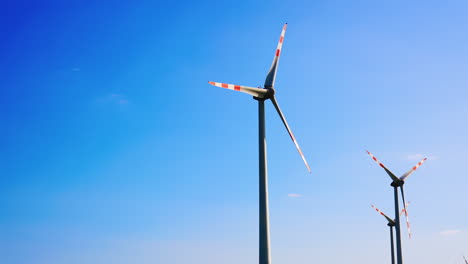 wind turbines generating clean energy. tall wind turbines spin against a clear blue sky, harnessing wind power for renewable energy production