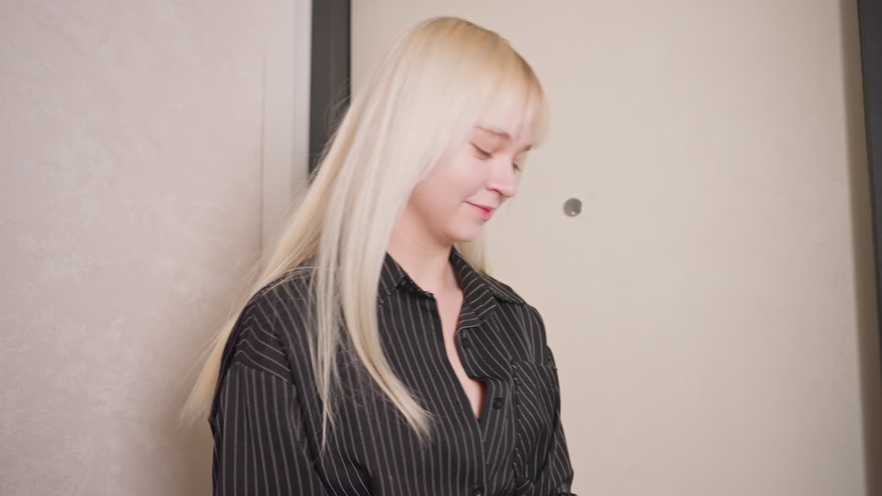 College girl with blonde hair enters modern hallway and warmly hugs brunette friend by door, sharing affectionate reunion full of joy and genuine connection during friendly meetup