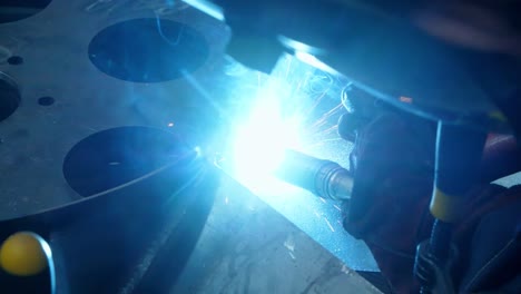 close-up of welding process with bright sparks. nozzle of welding machine