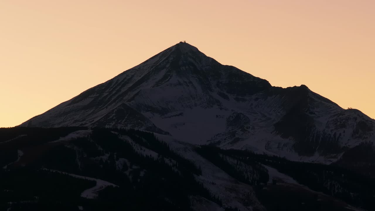 tomada cinematográfica de un avión no tripulado del pico de la montaña solitaria al atardecer en montana