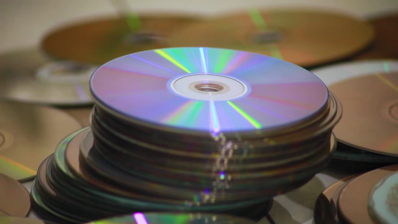 Dolly shot of a closeup of piles of old compact discs