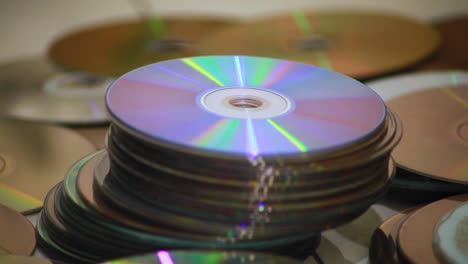 Dolly shot of a closeup of piles of old compact discs