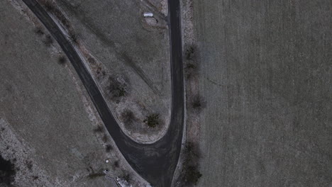 flying over a path overlooking the surrounding countryside during a light beginning snowfall