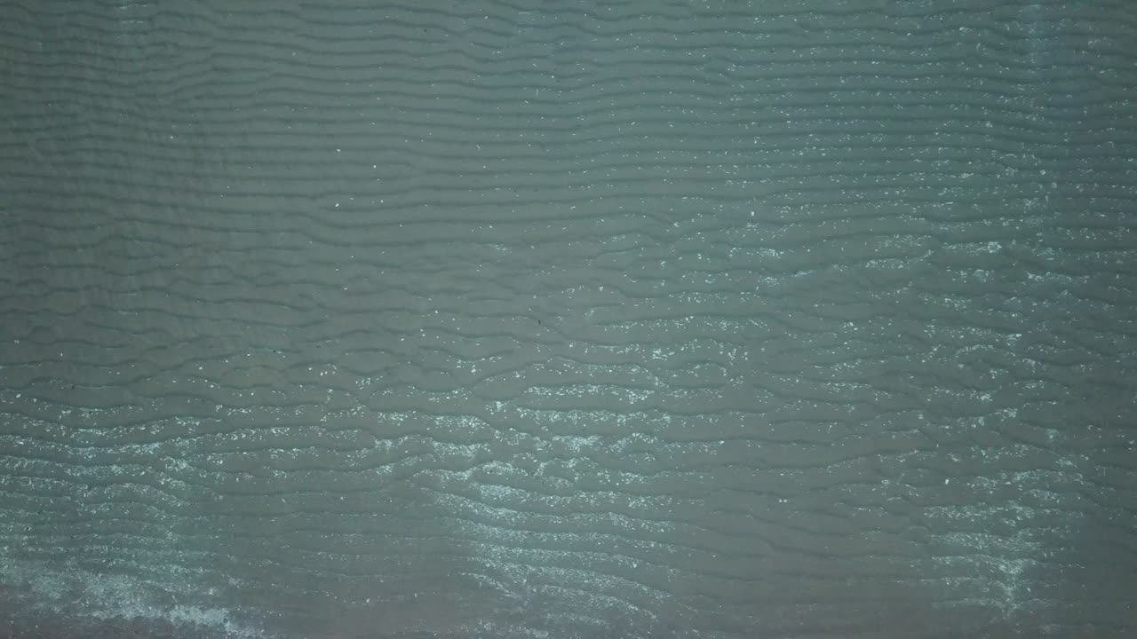 vista aérea de los pájaros mirando hacia abajo a las olas del mar que se estrellan. verde y azul vista superior del mar drone, imágenes de drones, 4k