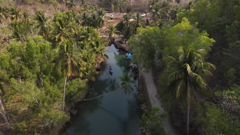 aerial view of blue boats running on the cokel river, pacitan, indonesia