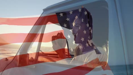 animación de la bandera estadounidense ondeando sobre una mujer de raza mixta en un coche tomando fotos en la orilla del mar