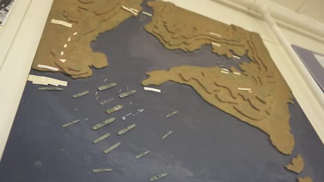 detailed miniature warships strategically positioning on tactical display board, meticulously recreating complex naval warfare scenario from historical military engagement
