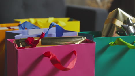close up de regalos envueltos en bolsas de colores con etiqueta en la mesa en el salón en casa 2