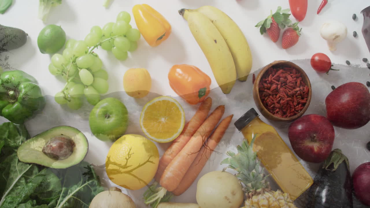 Assorted fresh fruits and vegetables arranged creatively on white background