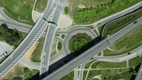 transportation themed aerial static drone footage capturing intricate highway junction with cars navigating complex roundabouts and intersecting roads with cars