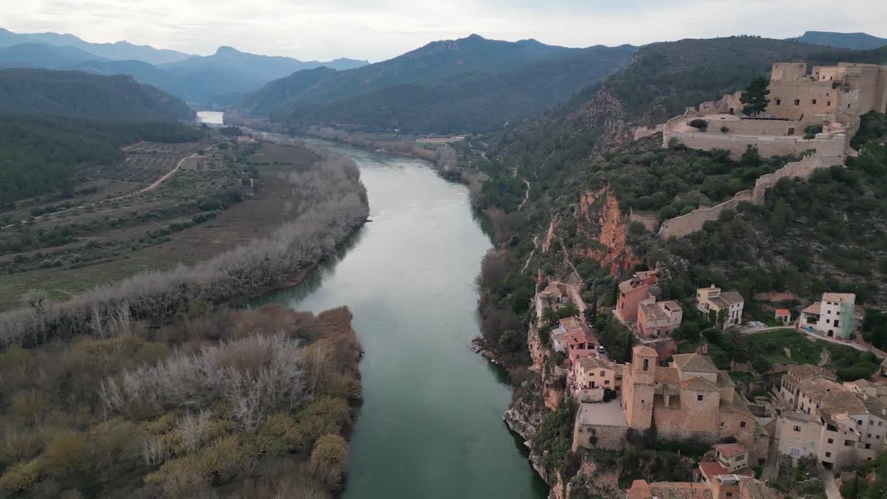 ciudad histórica de miravet con castillo medieval y el río ebro que fluye a través de la exuberante campiña española