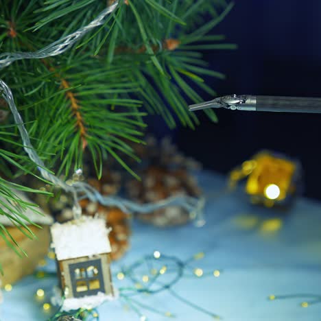robotic arm adjusting christmas decoration on the pine-tree. little claw dealing with delicate work. close up