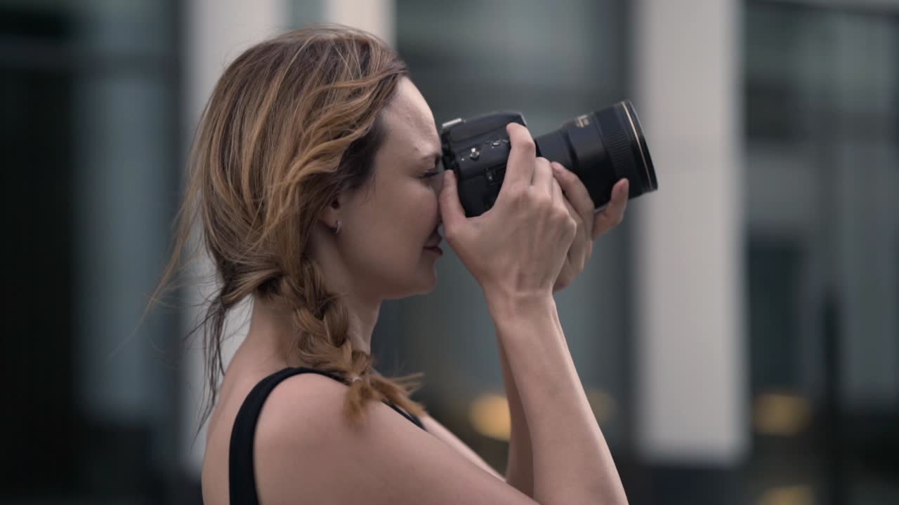 женщина фотографирует в городе.