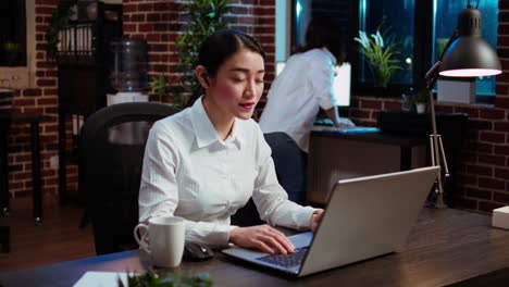 Worker-greeting-colleagues-during-business-meeting-on-videocall-in-office