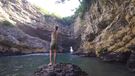 traveler young man in sea shore cave.