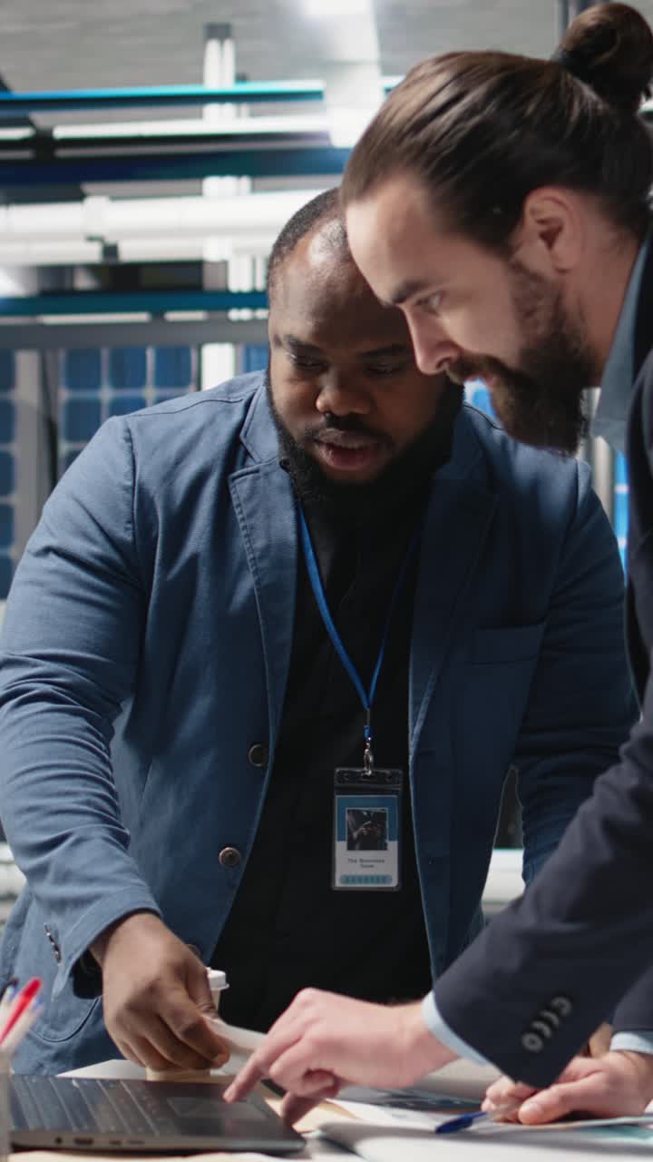 Vertical Video Technicians business people examine solar panel production in high tech facility