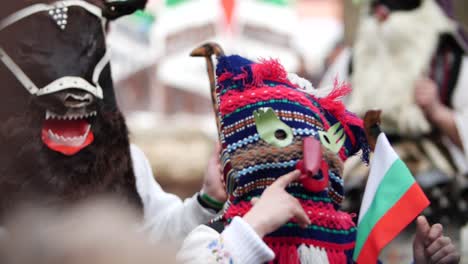 maska wyglądająca jak zrobiona ze starej bułgarskiej poduszki z czerwonym nosem i maską byka z tyłu