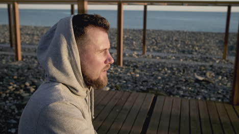 man in a hoodie on a beach