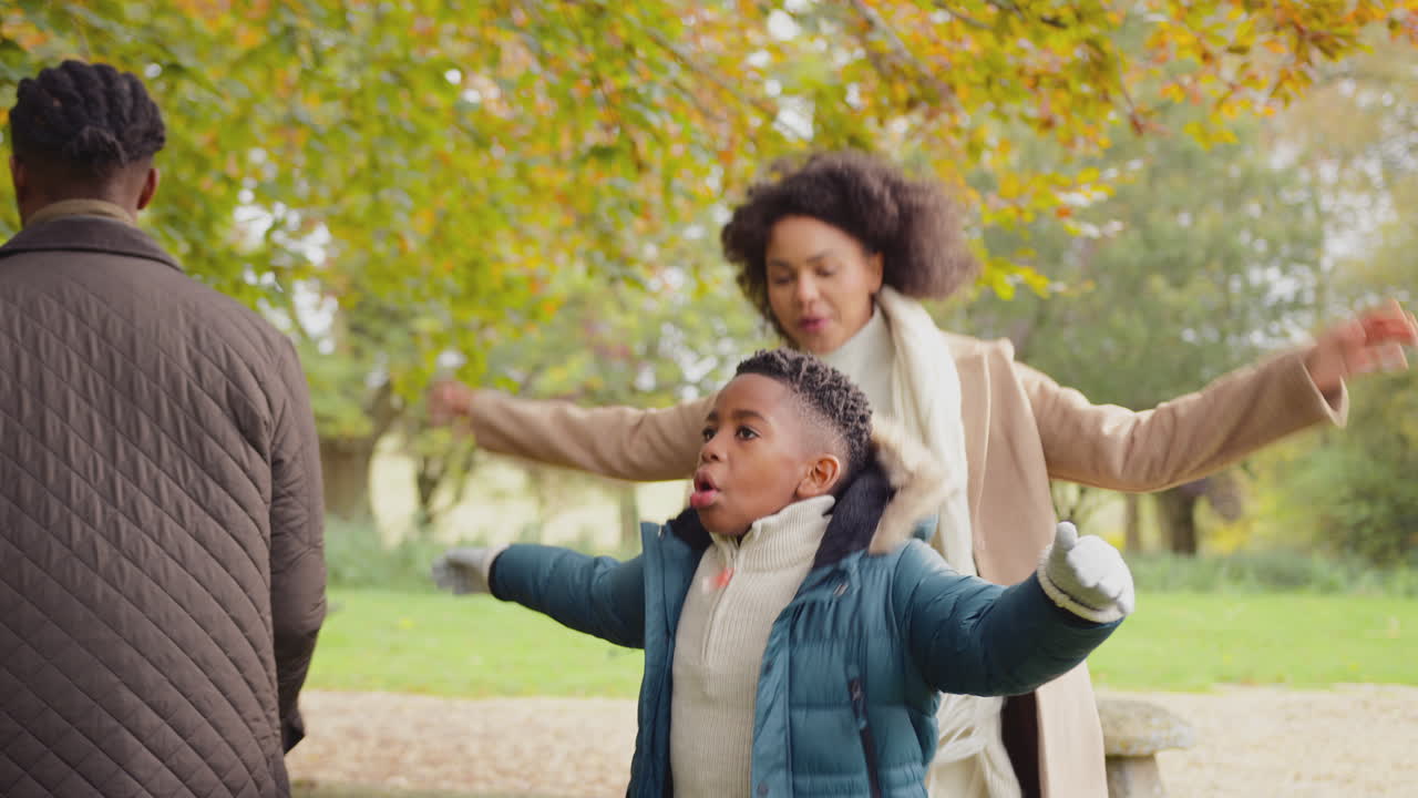 familia haciendo saltos para calentarse antes de caminar juntos por el campo de otoño - filmado en cámara lenta