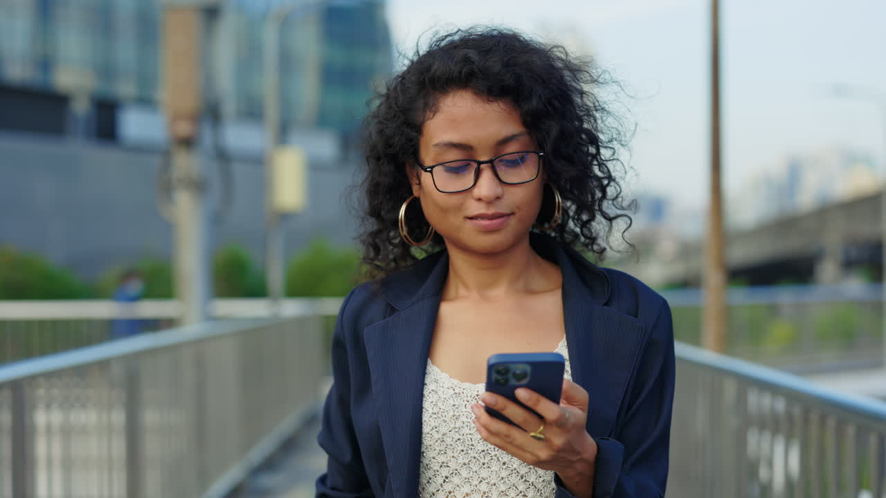 Woman Using Phone on a City Bridge