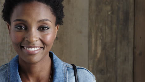 Retrato-De-Una-Hermosa-Joven-Afroamericana-Riendo-Feliz-Disfrutando-Del-éxito-Mujer-Negra-Con-Elegante-Chaqueta-Vaquera-Sobre-Fondo-De-Madera