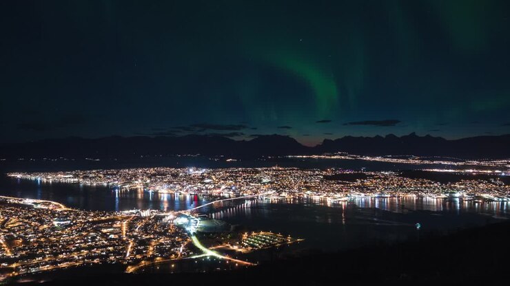 The Northern Lights shining in the night sky over Tromso city in Norway