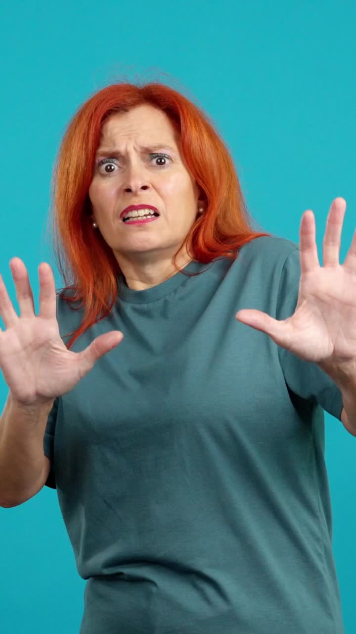 Woman showing extreme fear and shock with defensive gestures