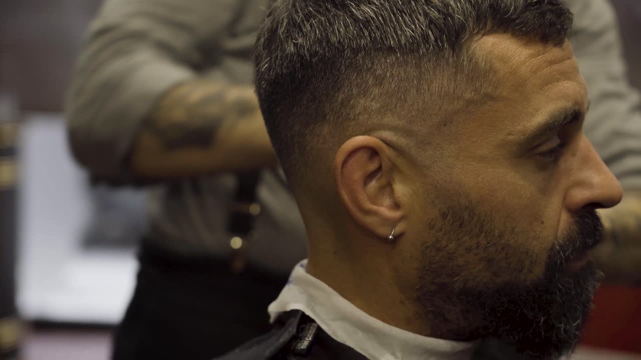peluquero con máquina de afeitar en una barbería