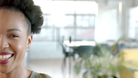 african american woman smiles brightly in a well-lit business office space with copy space
