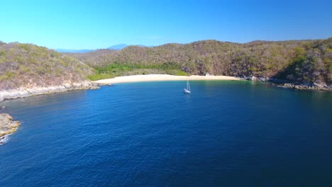 antena voladora delantera a velero anclado cerca de una pequeña cala de playa