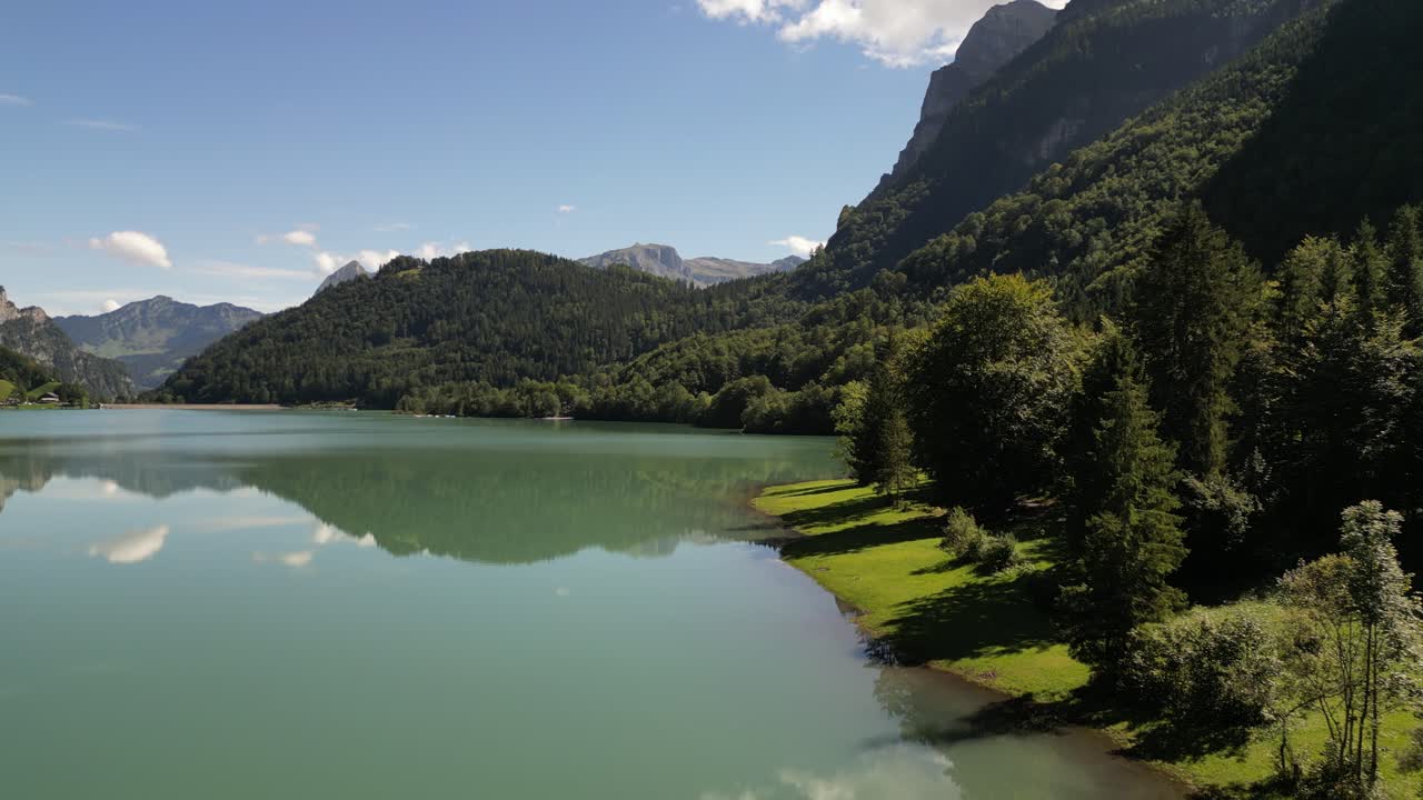 majestuosos picos, aguas cristalinas: vista aérea de bosques verdes y montañas a orillas del lago