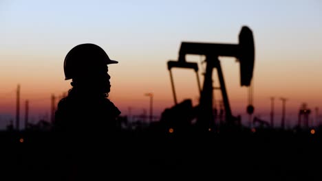 woman engineer inspects oil pumps at sunrise