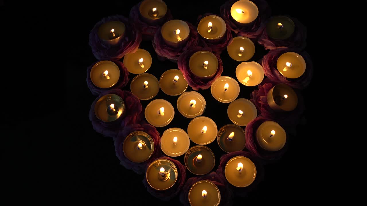 Rose e candele a forma di cuore.