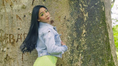 latina girl wearing a jacket turns and reveals her short green dress