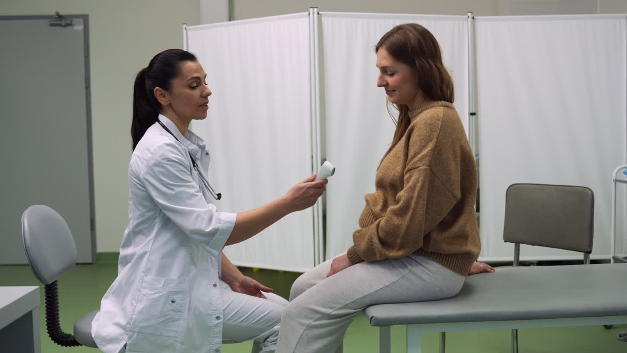 el médico comprueba la temperatura del paciente