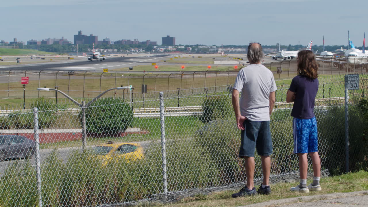 Father and Son Watch Plane Land at LaGuardia Airport from Park Overlooking Grand Central Parkway