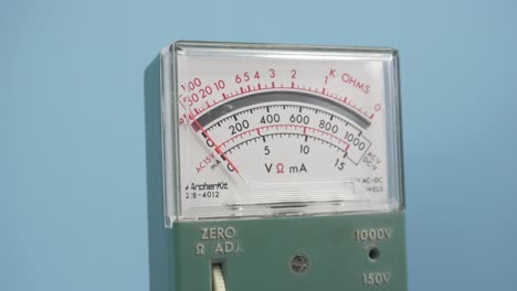 A-vintage-voltage-meter-on-a-blue-background-responding-to-a-voltage