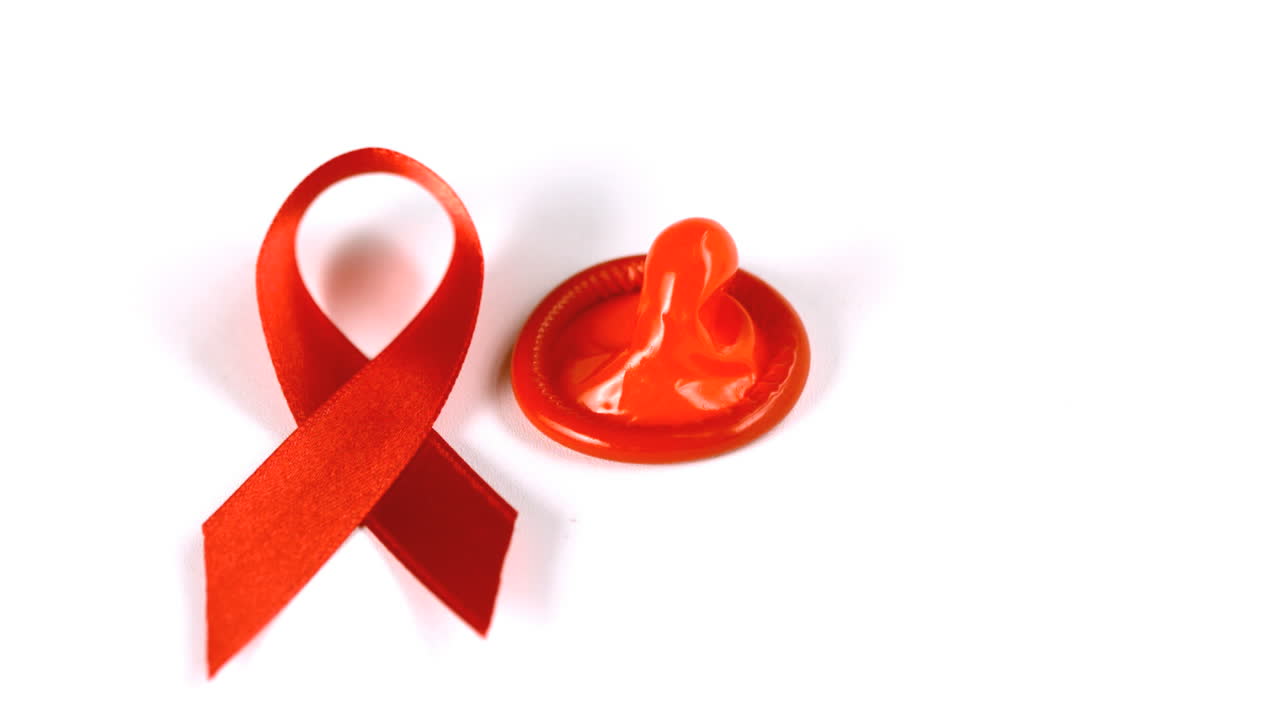 condón cayendo al lado de la cinta roja