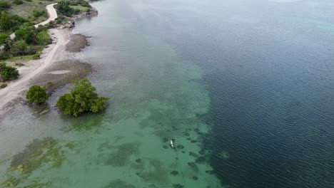 Mangrove-ecosystem,-crystal-clear-turquoise-water-and-a-small-traditional-fishing-canoe-boat-on-idyllic-remote-tropical-island-paradise