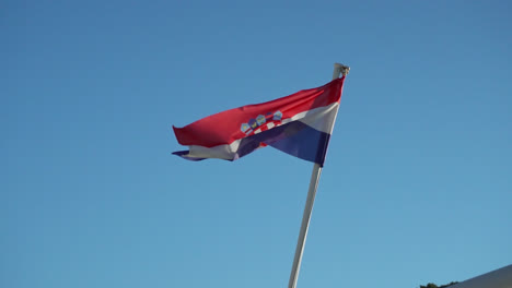 Cámara-Lenta-De-Una-Bandera-Croata-Ondeando-Contra-El-Cielo-Azul-Claro